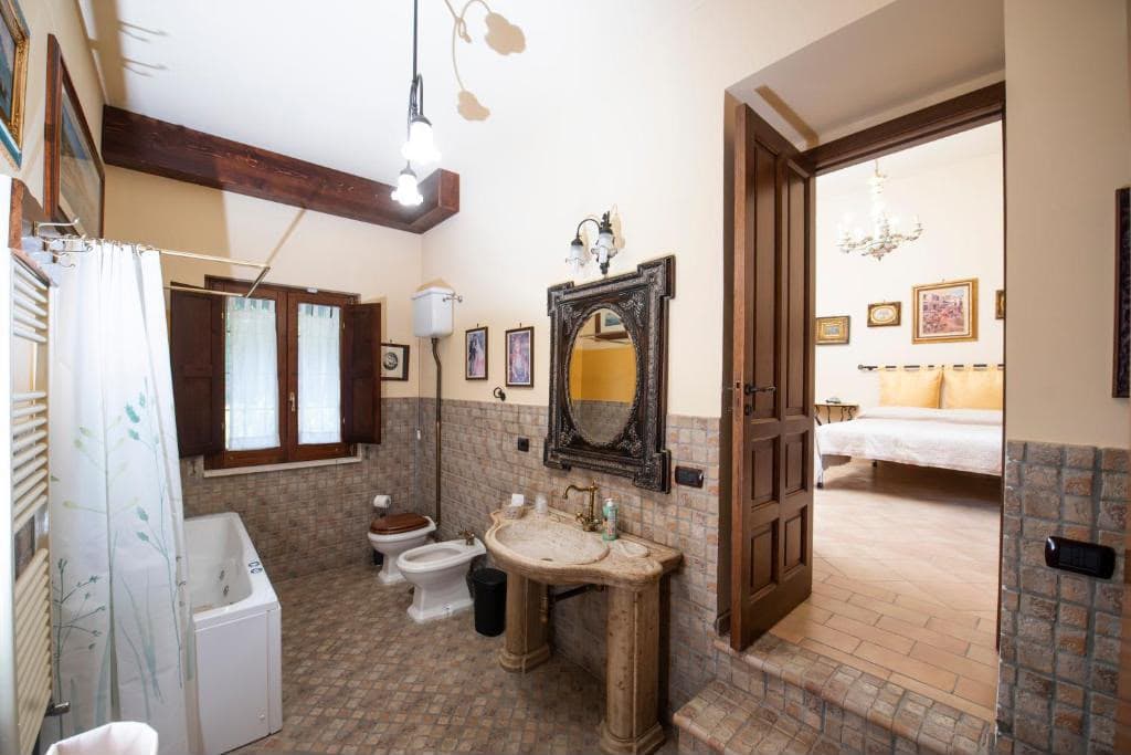 Bagno privato con vasca e lavabo in pietra