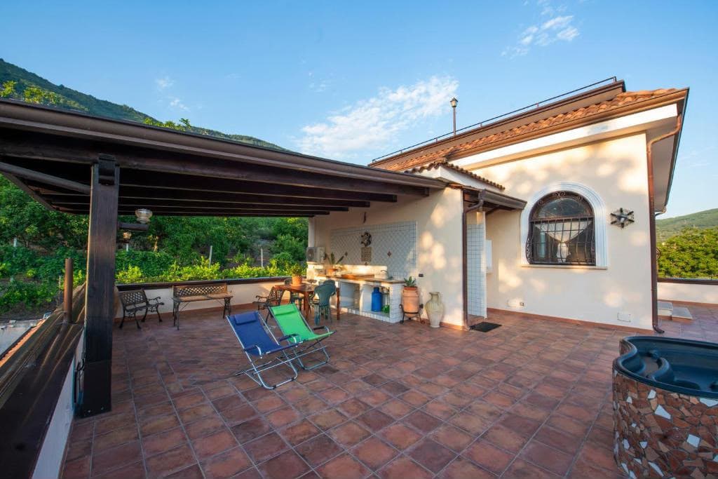 La terrazza con pergolato, angolo cucina e zona pranzo